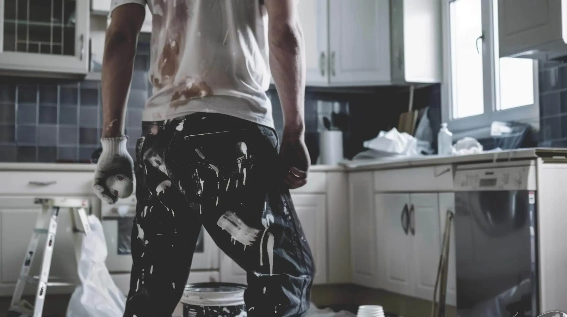 man painting in home being repaired before sale